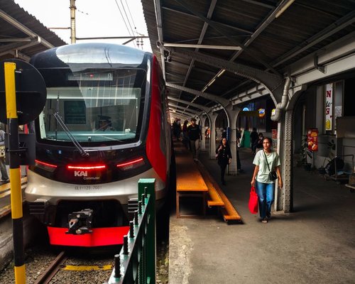 Commuters in a modern Indonesian city looking at screens